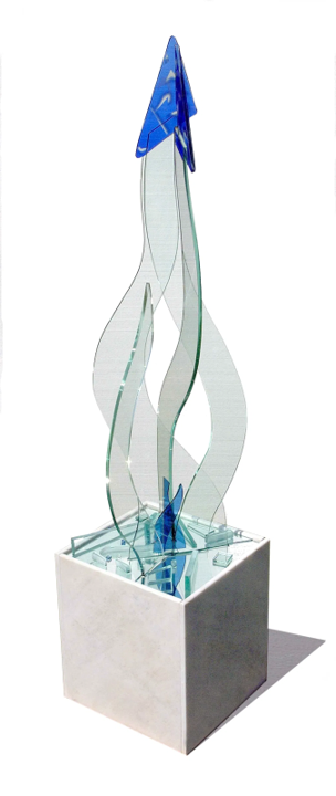 Bonded glass sculpture featuring fluid, flame-like clear forms rising to a sharp cobalt blue arrow tip, mounted on a white stone plinth.
