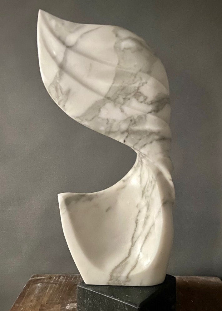 Billow 2 by Brendan Cullen, hand-carved from Carrara marble, featuring flowing organic curves with grey veining, a sculptural form evoking wind or water in motion, set on a dark stone base.