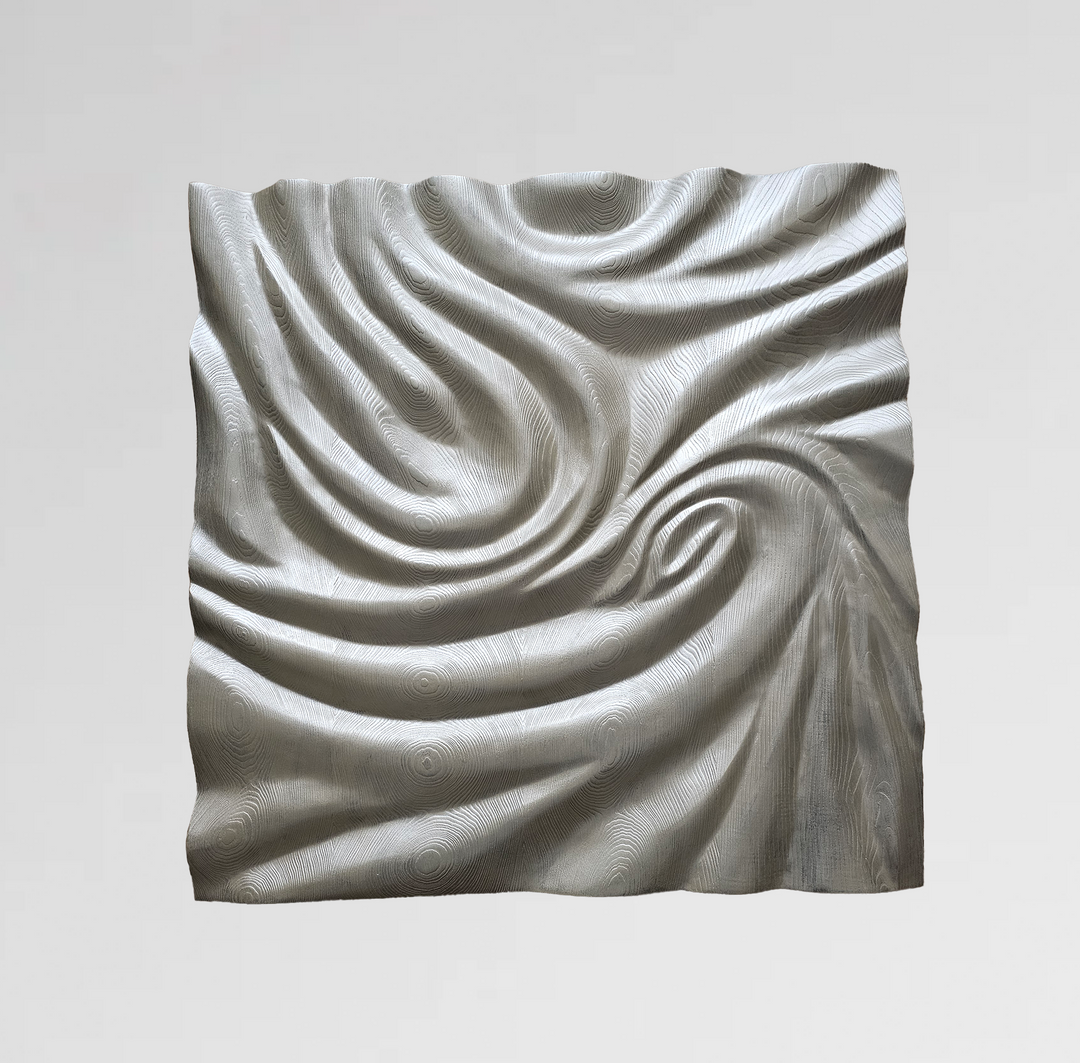 Light-toned wood wall sculpture with intricate swirling grain patterns and a soft, draped fabric-like form.