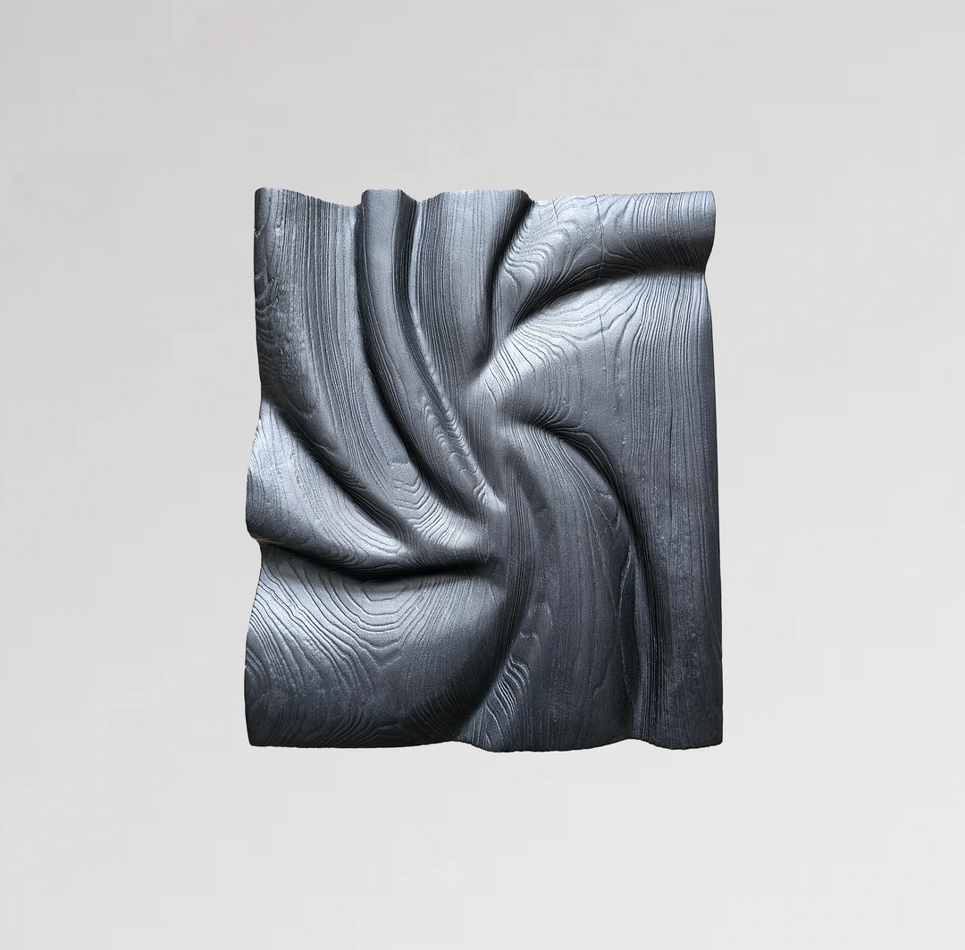 Textured black wood wall sculpture with swirling carved grain patterns and a folded fabric-like form.
