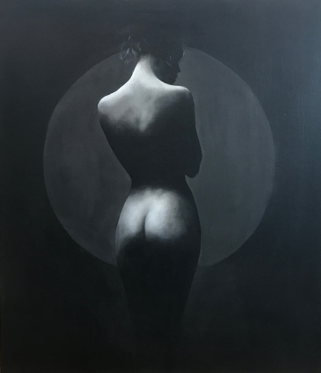 Monochrome nude female figure seen from behind with a circular light backdrop.