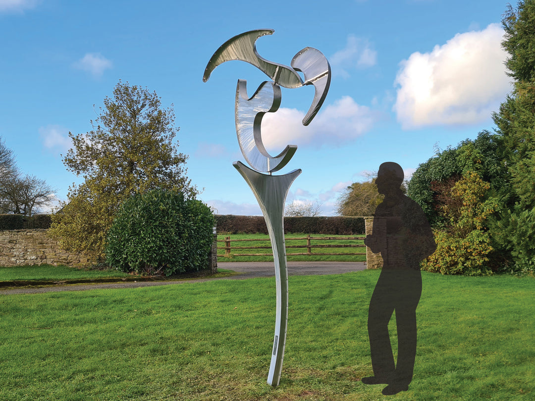 Abstract stainless steel kinetic sculpture with rotating, wind-driven elements and curved forms designed for outdoor movement