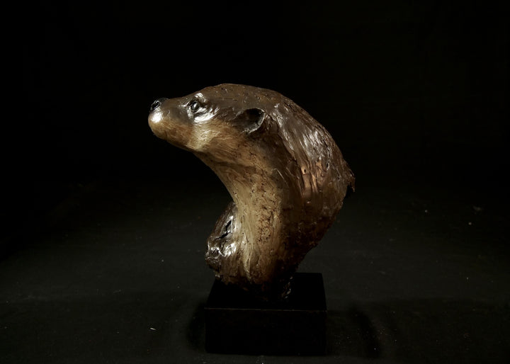 Cold cast stone sculpture of an otter head and neck titled Hindsight by Jamie Lord — finely detailed bust with sleek, sinuous form, warm brown fur tones, dark glassy eyes and alert, turned-back pose. Limited edition of 24 with signed Certificate of Authenticity.