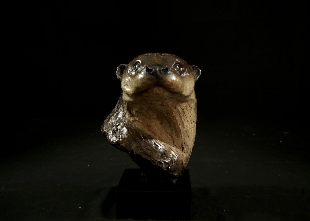 Cold cast stone sculpture of an otter head and neck titled Hindsight by Jamie Lord — finely detailed bust with sleek, sinuous form, warm brown fur tones, dark glassy eyes and alert, turned-back pose. Limited edition of 24 with signed Certificate of Authenticity.