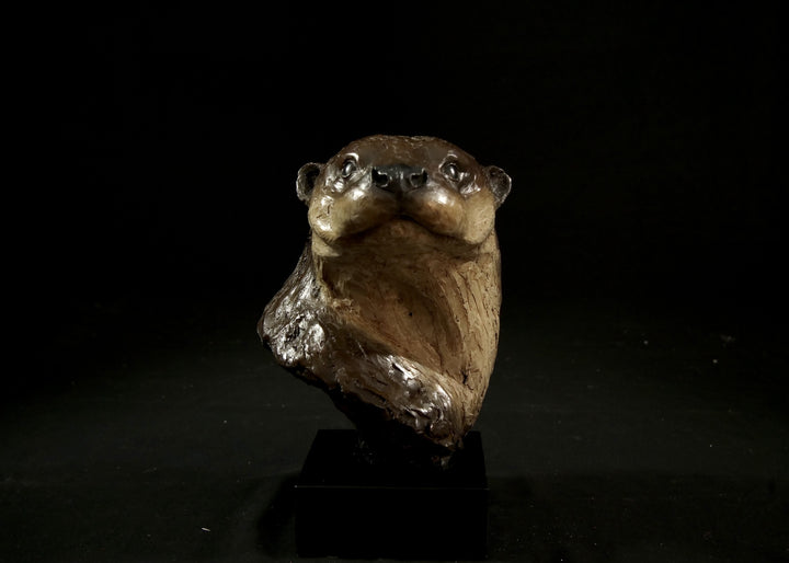 Cold cast stone sculpture of an otter head and neck titled Hindsight by Jamie Lord — finely detailed bust with sleek, sinuous form, warm brown fur tones, dark glassy eyes and alert, turned-back pose. Limited edition of 24 with signed Certificate of Authenticity.