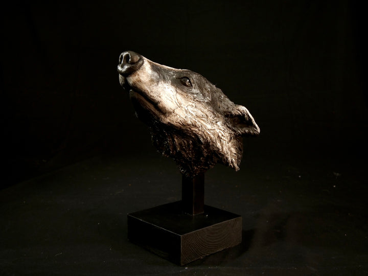 Cold cast slate sculpture of a badger titled Remnant by Jamie Lord — expressive woodland animal bust with textured black-and-grey fur, soft white facial markings, and an upward, reflective gaze. Limited edition of 12 with signed Certificate of Authenticity.