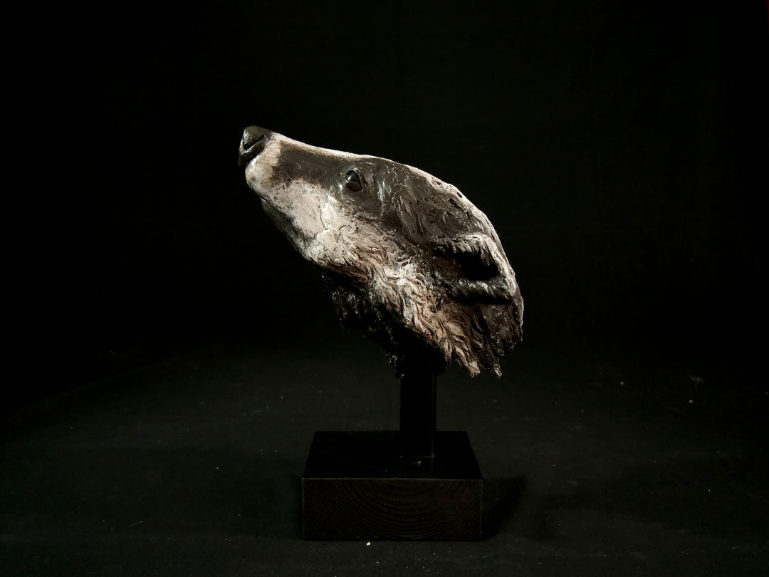 Cold cast slate sculpture of a badger titled Remnant by Jamie Lord — expressive woodland animal bust with textured black-and-grey fur, soft white facial markings, and an upward, reflective gaze. Limited edition of 12 with signed Certificate of Authenticity.