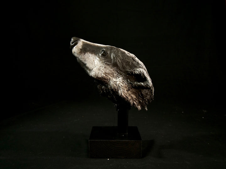 Cold cast slate sculpture of a badger titled Remnant by Jamie Lord — expressive woodland animal bust with textured black-and-grey fur, soft white facial markings, and an upward, reflective gaze. Limited edition of 12 with signed Certificate of Authenticity.