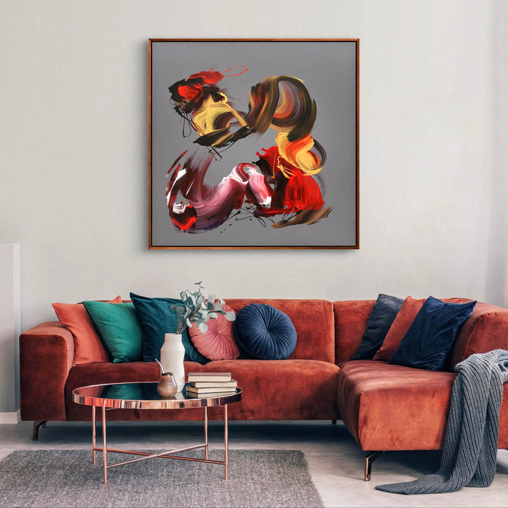 An expressive abstract acrylic painting on square canvas featuring bold, gestural brushstrokes in red, magenta, gold, burnt sienna, and black. The background is a smooth grey taupe, offering a neutral contrast to the vivid, swirling forms. The composition conveys dynamic movement and emotion, with layered, ribbon-like textures and flicks of paint that give a sense of energy and rhythm.