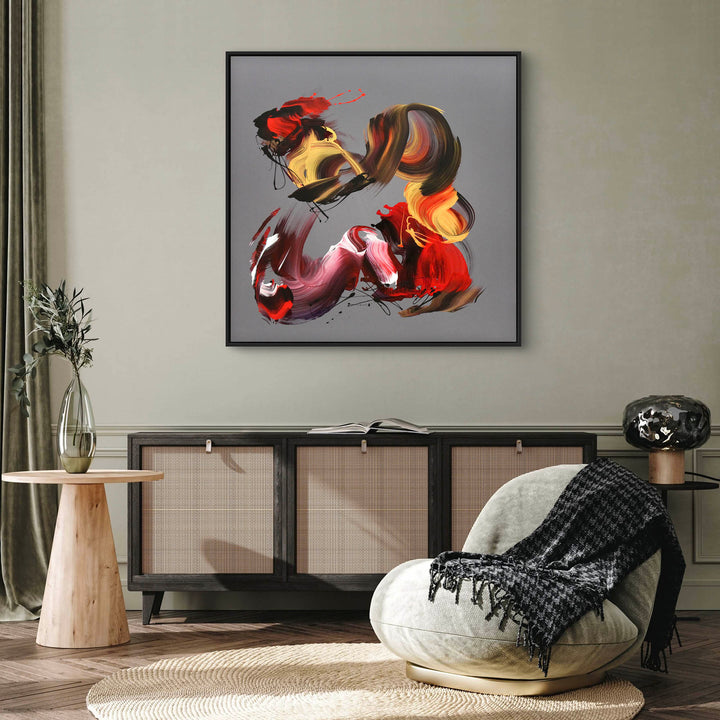 An expressive abstract acrylic painting on square canvas featuring bold, gestural brushstrokes in red, magenta, gold, burnt sienna, and black. The background is a smooth grey taupe, offering a neutral contrast to the vivid, swirling forms. The composition conveys dynamic movement and emotion, with layered, ribbon-like textures and flicks of paint that give a sense of energy and rhythm.
