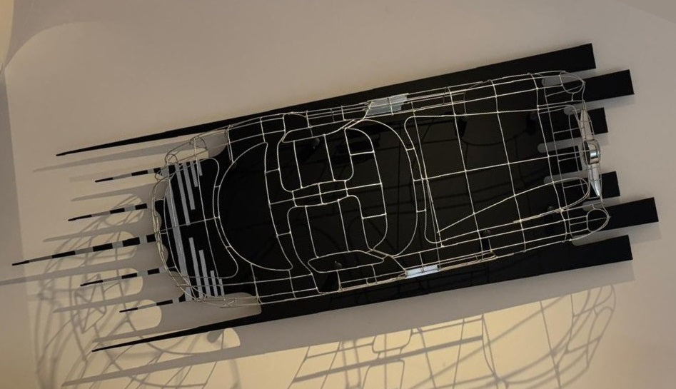 Handcrafted Mercedes-Benz 300 SLR Coupé wire sculpture by Chris Twitchell, inspired by the legendary 1955 Uhlenhaut prototype designed by Friedrich Geiger. Sculpted from precision-formed steel and finished in silver grey DB180, this wall-mounted piece reimagines one of the rarest and most valuable cars ever built — a celebration of German engineering excellence, aerodynamic form, and timeless automotive design.