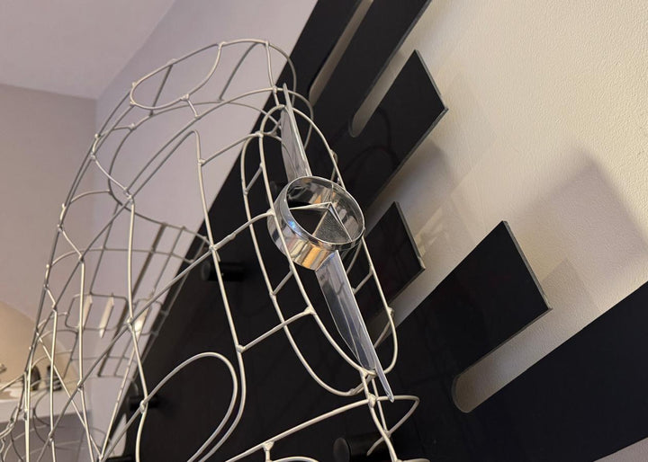 Handcrafted Mercedes-Benz 300 SLR Coupé wire sculpture by Chris Twitchell, inspired by the legendary 1955 Uhlenhaut prototype designed by Friedrich Geiger. Sculpted from precision-formed steel and finished in silver grey DB180, this wall-mounted piece reimagines one of the rarest and most valuable cars ever built — a celebration of German engineering excellence, aerodynamic form, and timeless automotive design.