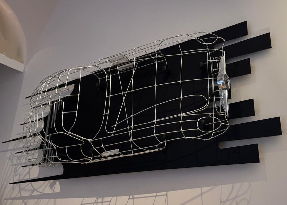 Handcrafted Mercedes-Benz 300 SLR Coupé wire sculpture by Chris Twitchell, inspired by the legendary 1955 Uhlenhaut prototype designed by Friedrich Geiger. Sculpted from precision-formed steel and finished in silver grey DB180, this wall-mounted piece reimagines one of the rarest and most valuable cars ever built — a celebration of German engineering excellence, aerodynamic form, and timeless automotive design.