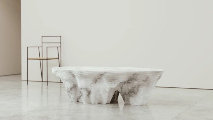 Duffy London Monument Valley Dining Table carved from marble with sculptural canyon-like base and glass top, inspired by natural rock formations.