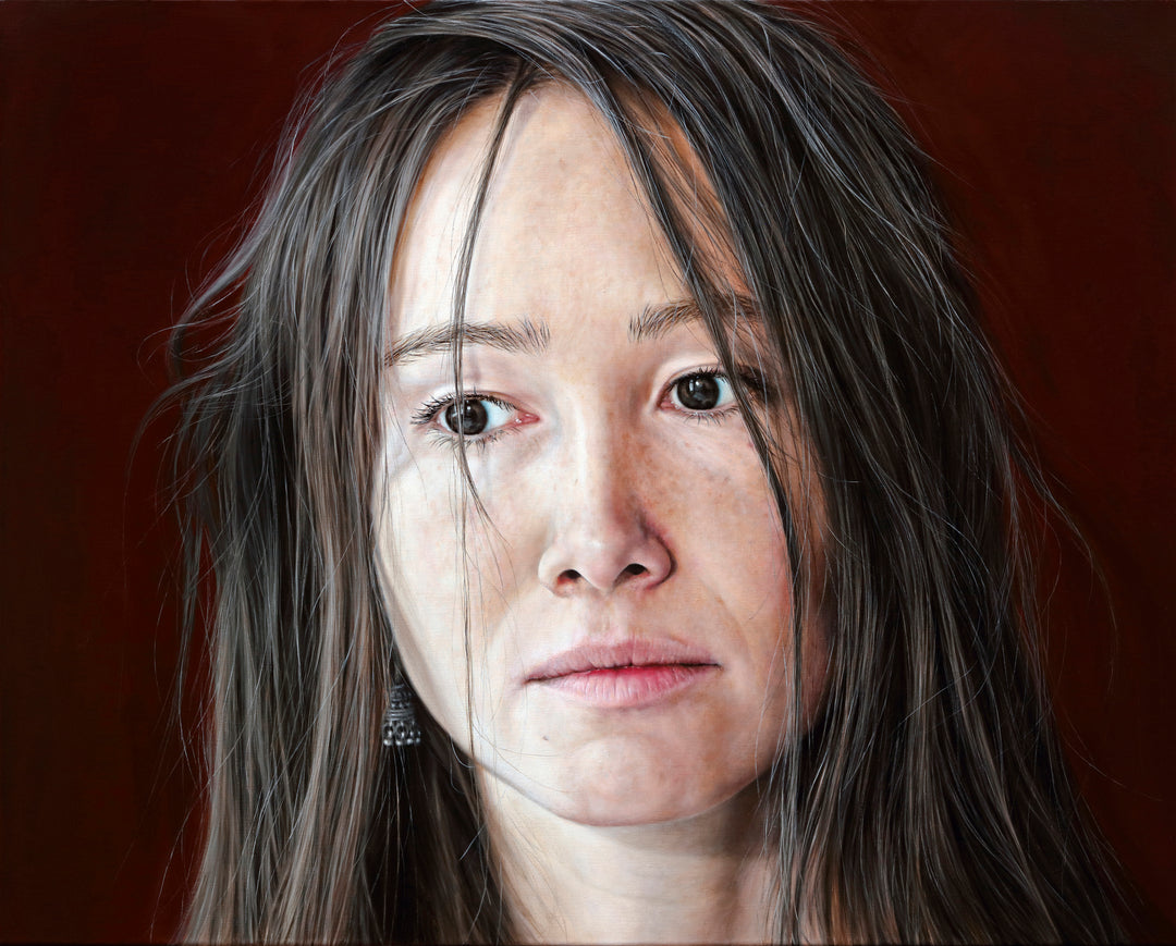 Arina Gordienko hyperrealist oil painting Lend Me the Past, a close-up portrait of a young woman with long brown hair falling loosely around her face, her expression marked by sadness and introspection. Set against a deep red background, the work conveys themes of memory, grief, and the longing to rewrite painful moments from the past.
