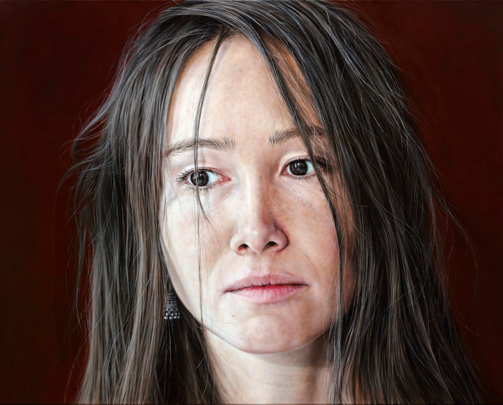 Arina Gordienko hyperrealist oil painting Lend Me the Past, a close-up portrait of a young woman with long brown hair falling loosely around her face, her expression marked by sadness and introspection. Set against a deep red background, the work conveys themes of memory, grief, and the longing to rewrite painful moments from the past.