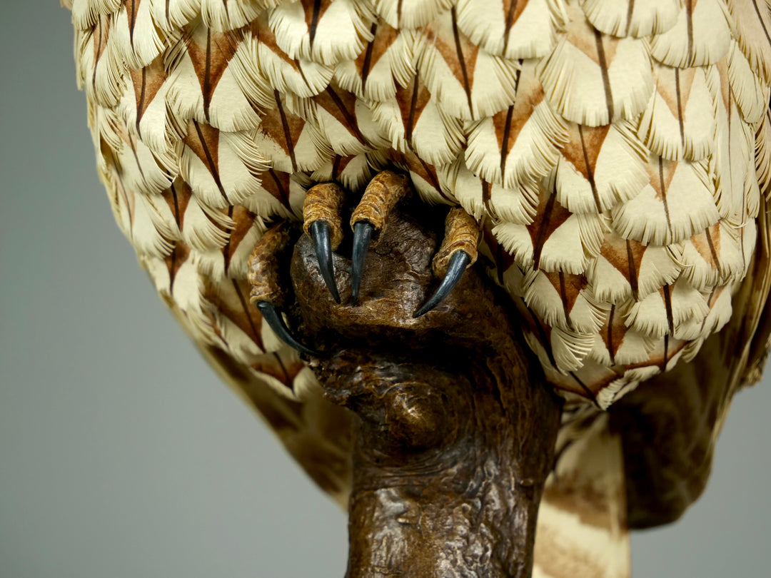 Nocturne tawny owl sculpture by Jamie Lord with layered archival paper feathers and cold cast bronze base on branch