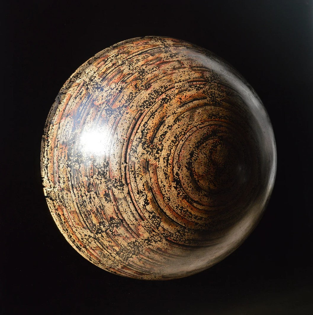 Textured hemispherical sculpture by Richard Slee titled “Nebula Core.” Made from hundreds of upright bamboo skewers embedded in black resin, the surface is meticulously hand coloured with pencil in swirling, planetary patterns. The final effect resembles a cosmic vortex or galactic core, rendered in warm earthy tones with rich texture and depth.