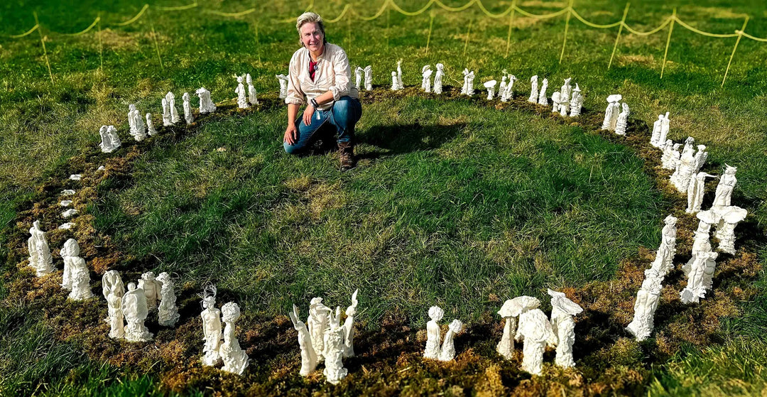 Eve Shepherd Children of Nature sculptural installation featuring around 100 individual porcelain hybrid figures combining human, animal, plant and fungal forms, arranged in a large illuminated fairy ring surrounded by natural moss.