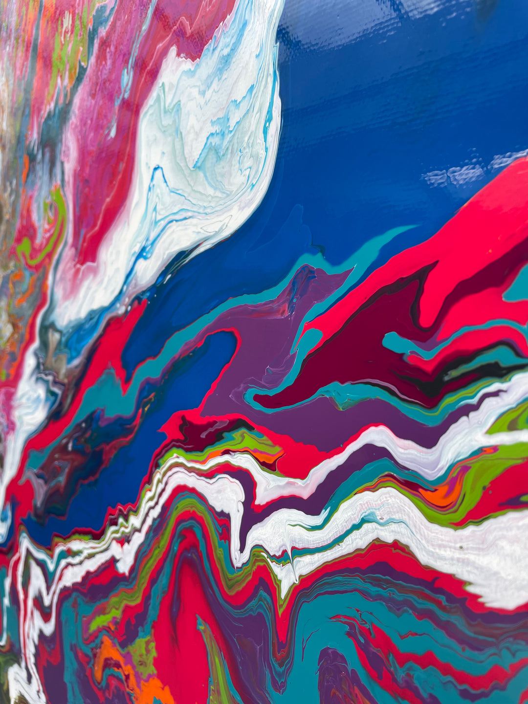 Large square abstract painting “United We Stand” by Swarez — a high-impact explosion of swirling magenta and deep blue blending with metallic gold, copper, turquoise, vivid orange, lime green, crisp white and rich black. Layers of glossy enamel paint radiate outward from the centre in fluid marbled streams, creating a dramatic, multi-directional composition full of energy and movement.