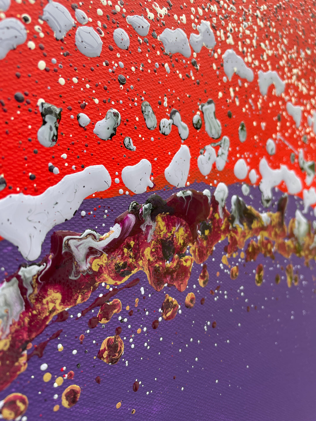 Large abstract painting “Ellipsis” by Swarez — bold square composition with a deep violet central circle surrounded by concentric rings of paint droplets and splashes on a vivid matte red background. Energetic, dynamic halo effect created by spin technique.