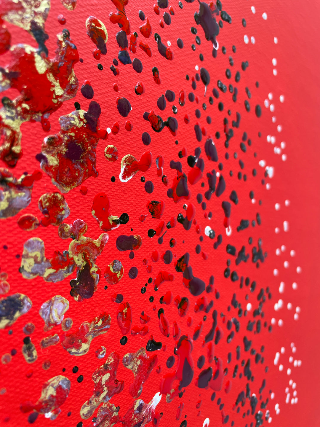 Large abstract painting “Ellipsis” by Swarez — bold square composition with a deep violet central circle surrounded by concentric rings of paint droplets and splashes on a vivid matte red background. Energetic, dynamic halo effect created by spin technique.