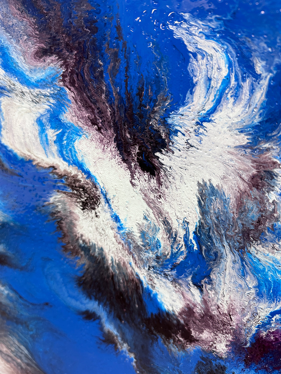 Large abstract painting “Atomic Butterfly” by Swarez — dramatic centrifugal spin art with explosive bursts of cobalt blue, electric turquoise, deep violet purple, crisp white, and black radiating from the centre across a heavily textured enamel surface.