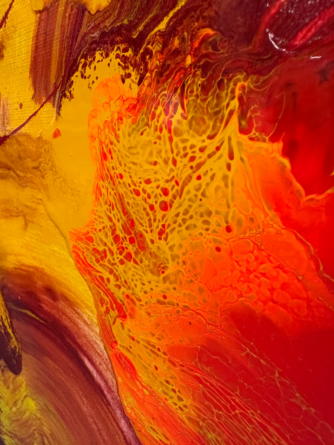 Large abstract painting “Crocosmia” by Swarez — vibrant swirling composition of fiery reds, deep crimson, burnt orange, radiant yellow, and accents of magenta, pink, purple, black, and white. Expressive layered enamel paint with fluid circular motions and botanical-inspired energy.