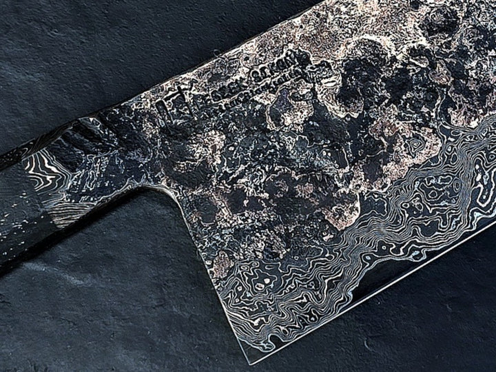 One-of-a-kind Cu-Ni-Mascus Nakiri knife by Leszek Sikon, showcasing 8120 layers of Damascus forged from Spicy White steel, O1 tool steel, copper, nickel, and brass. The blade features a rich, geological pattern with molten textures and wave-like lines, hand-forged over 100 hours with an S-profile for food release and finished with a custom jeans micarta handle embedded with copper and steel mesh.