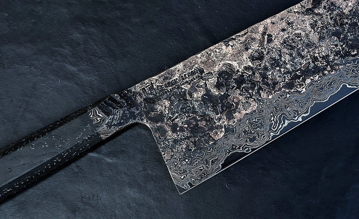 One-of-a-kind Cu-Ni-Mascus Nakiri knife by Leszek Sikon, showcasing 8120 layers of Damascus forged from Spicy White steel, O1 tool steel, copper, nickel, and brass. The blade features a rich, geological pattern with molten textures and wave-like lines, hand-forged over 100 hours with an S-profile for food release and finished with a custom jeans micarta handle embedded with copper and steel mesh.