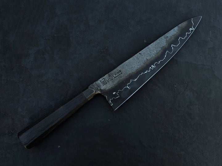 Leszek Sikon San Mai Chef Graphite Gyuto hand-forged chef’s knife featuring a dark San Mai carbon steel blade with visible hamon line and bog oak handle.