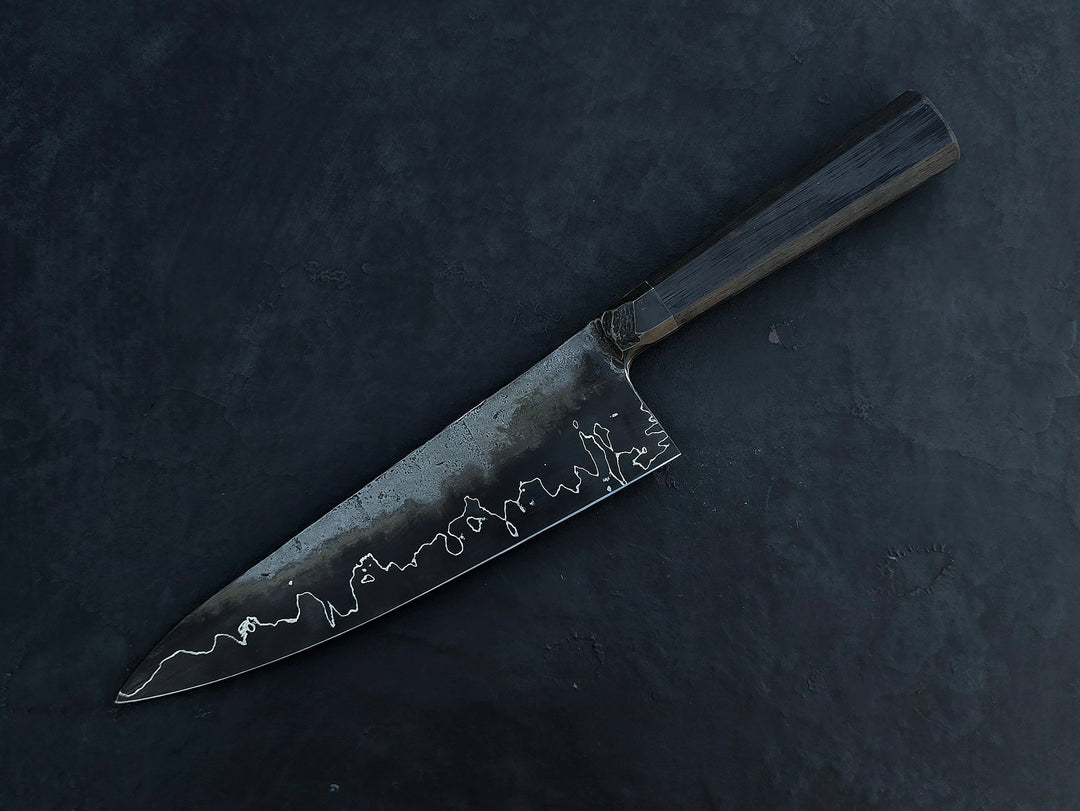Leszek Sikon San Mai Chef Graphite Gyuto hand-forged chef’s knife featuring a dark San Mai carbon steel blade with visible hamon line and bog oak handle.