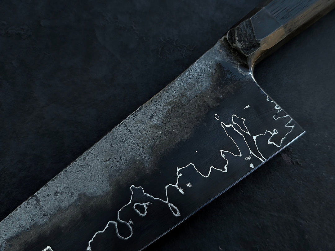 Leszek Sikon San Mai Chef Graphite Gyuto hand-forged chef’s knife featuring a dark San Mai carbon steel blade with visible hamon line and bog oak handle.