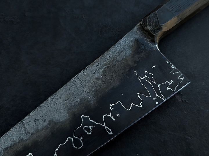 Leszek Sikon San Mai Chef Graphite Gyuto hand-forged chef’s knife featuring a dark San Mai carbon steel blade with visible hamon line and bog oak handle.