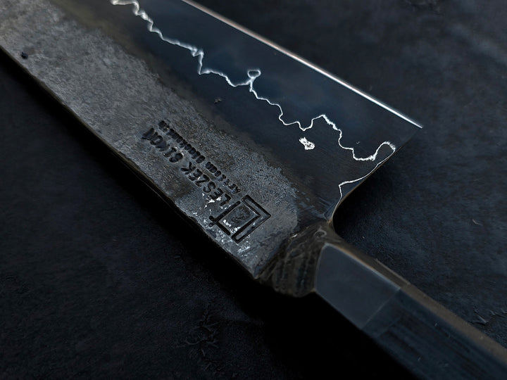 Leszek Sikon San Mai Chef Graphite Gyuto hand-forged chef’s knife featuring a dark San Mai carbon steel blade with visible hamon line and bog oak handle.