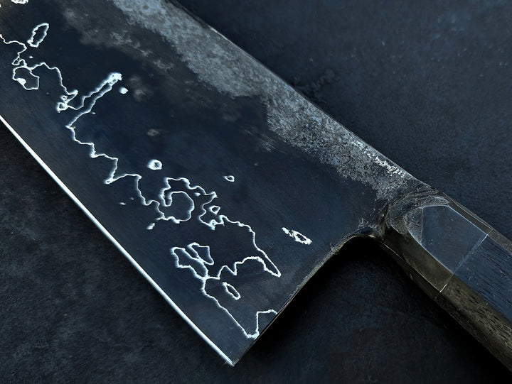 Leszek Sikon San Mai Graphite Nakiri hand-forged kitchen knife featuring a dark laminated carbon steel blade with visible hamon line and bog oak handle.