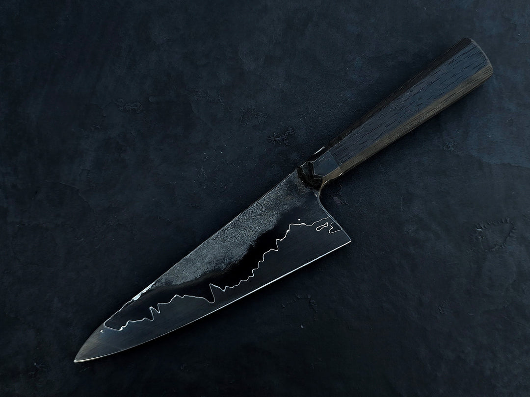 Leszek Sikon San Mai Graphite Petty hand-forged kitchen knife with laminated carbon steel blade, visible hamon line and bog oak handle.