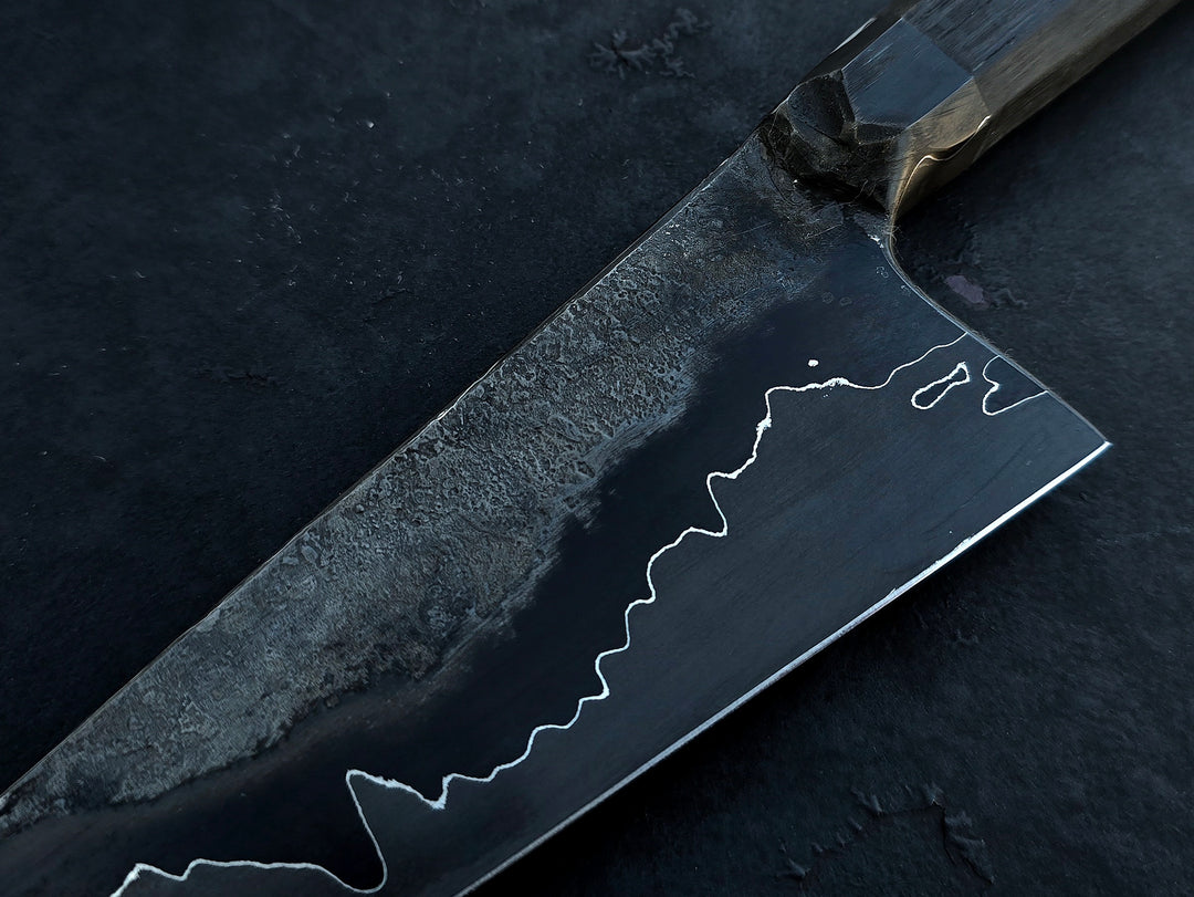 Leszek Sikon San Mai Graphite Petty hand-forged kitchen knife with laminated carbon steel blade, visible hamon line and bog oak handle.