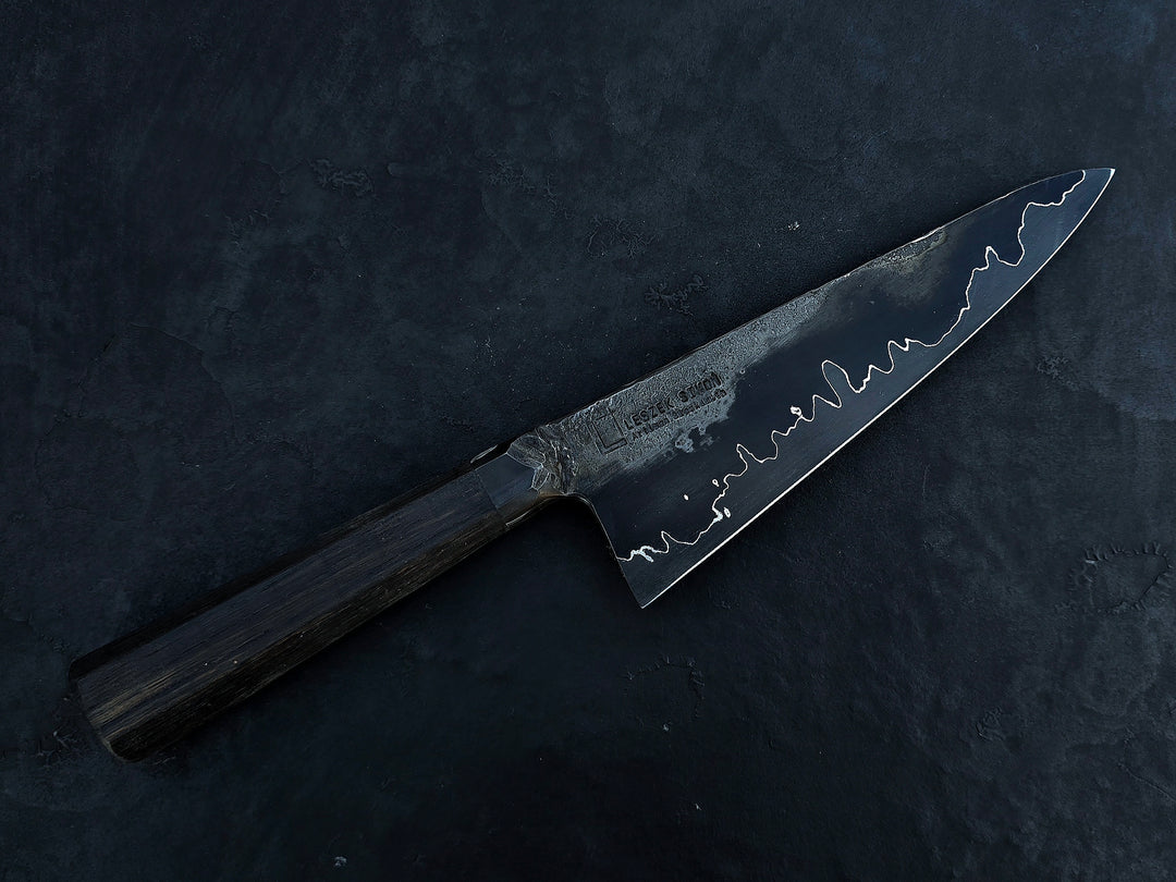 Leszek Sikon San Mai Graphite Petty hand-forged kitchen knife with laminated carbon steel blade, visible hamon line and bog oak handle.