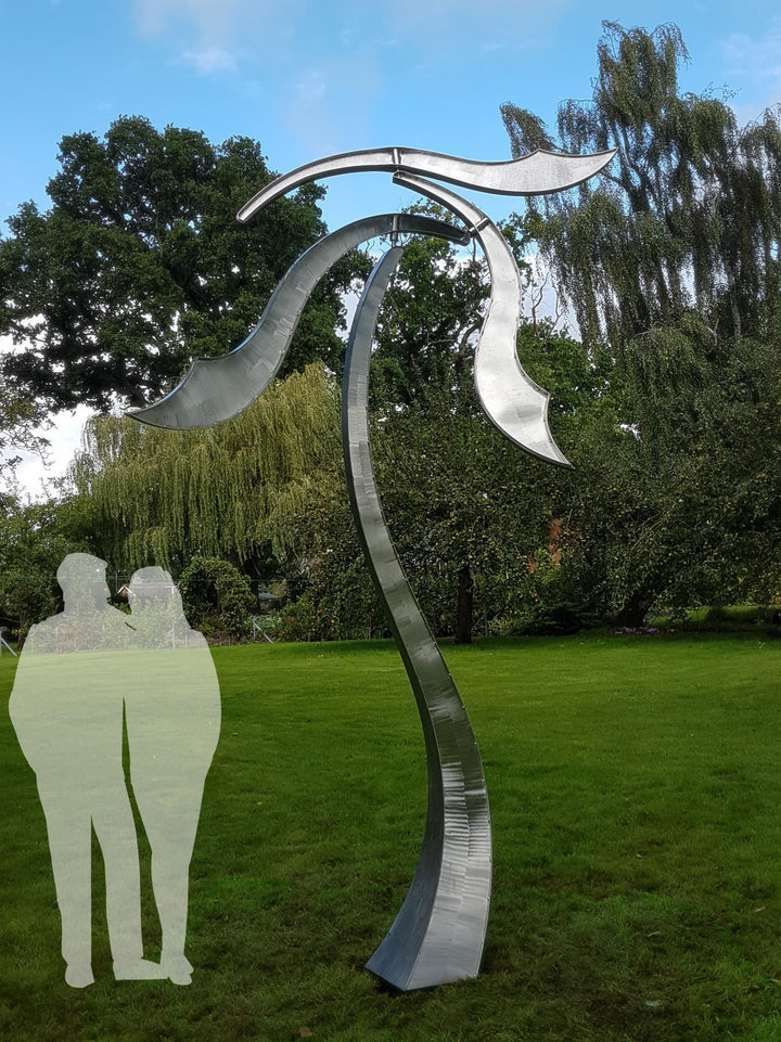 Abstract stainless steel kinetic sculpture with wind-responsive curved elements designed to shift and flow with natural movement