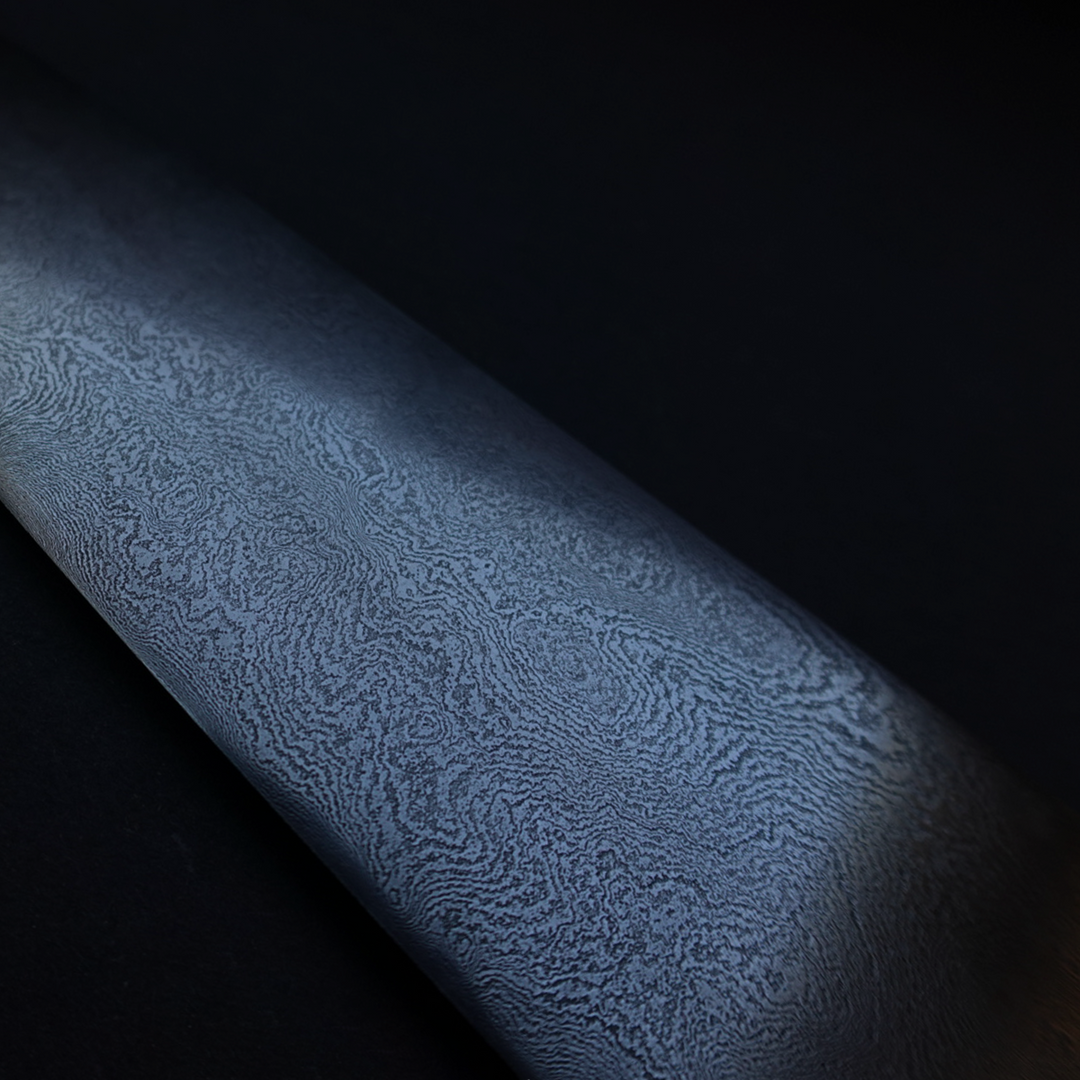 210mm high-layer Damascus chef’s knife, hand-forged from 15N20 and 80Crv2 carbon steels, featuring a deeply etched, topographic blade surface and a sculpted black wood handle with matching ferrule.