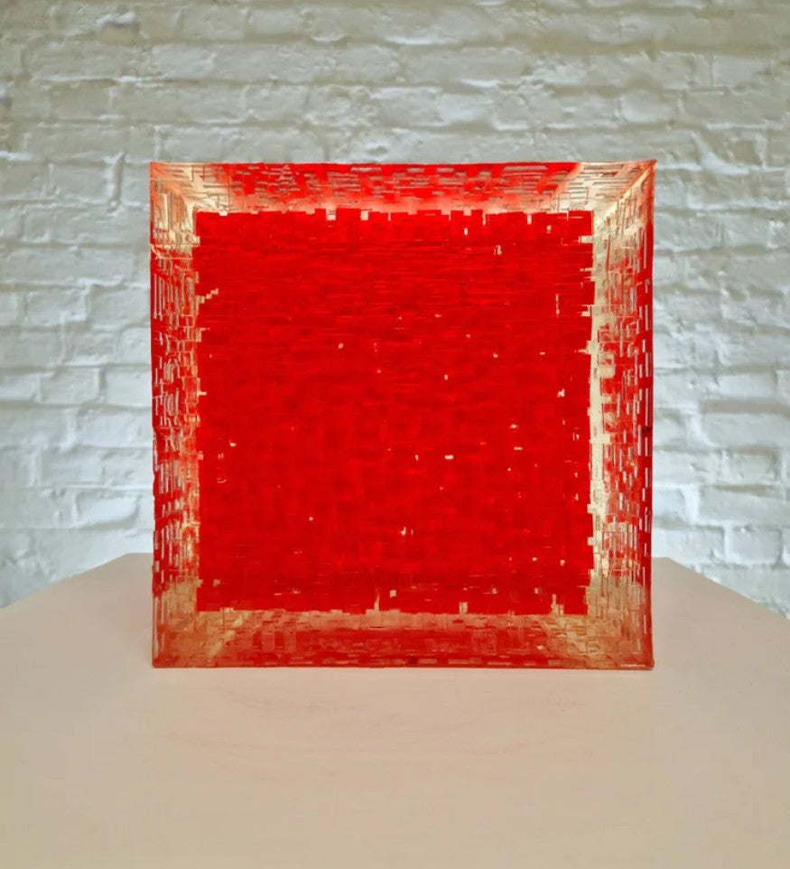 A one-off sculptural cube by Richard Slee, constructed from neon red acrylic and clear resin. The work features a dense, layered grid pattern that plays with light, depth, and shadow—creating a luminous, architectural object with a strong geometric presence. The cube glows from within, drawing the viewer into its intricate interior.