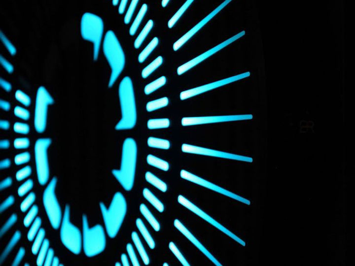 “Tempus Obsidian” by Ben Rousseau – a limited-edition illuminated wall timepiece crafted from grey mirrored glass and brass-tinted aluminium with LEDs. Inspired by obsidian, it radiates calm through subtle light and refined design.

