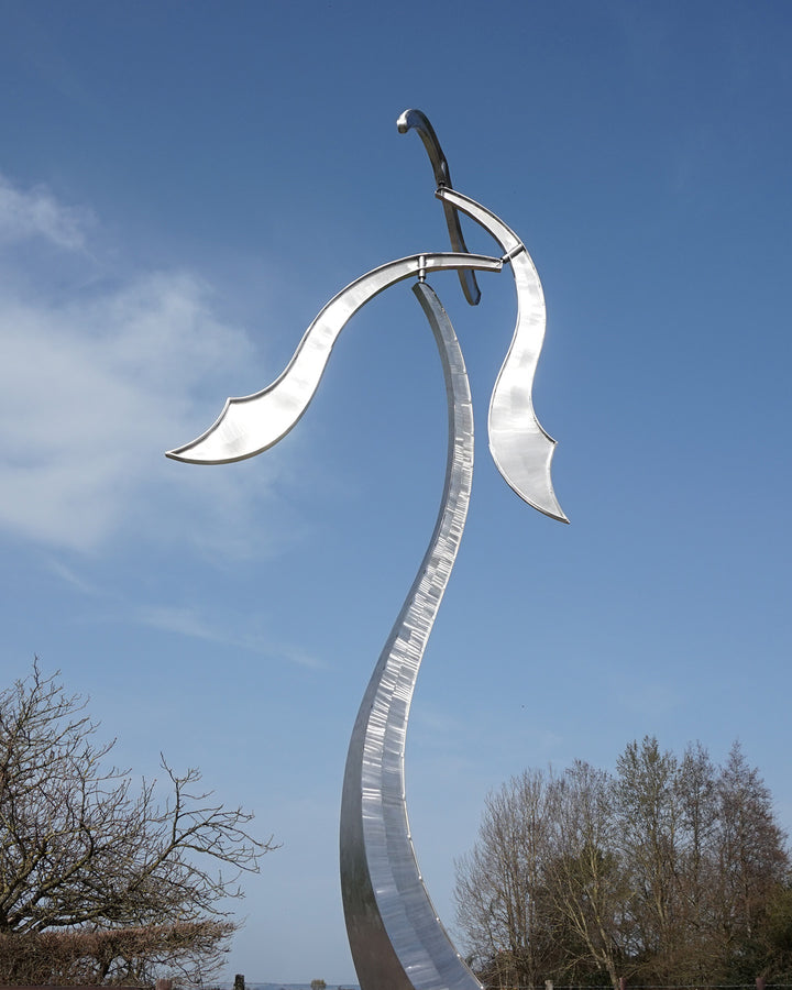 Abstract stainless steel kinetic sculpture with wind-responsive curved elements designed to shift and flow with natural movement