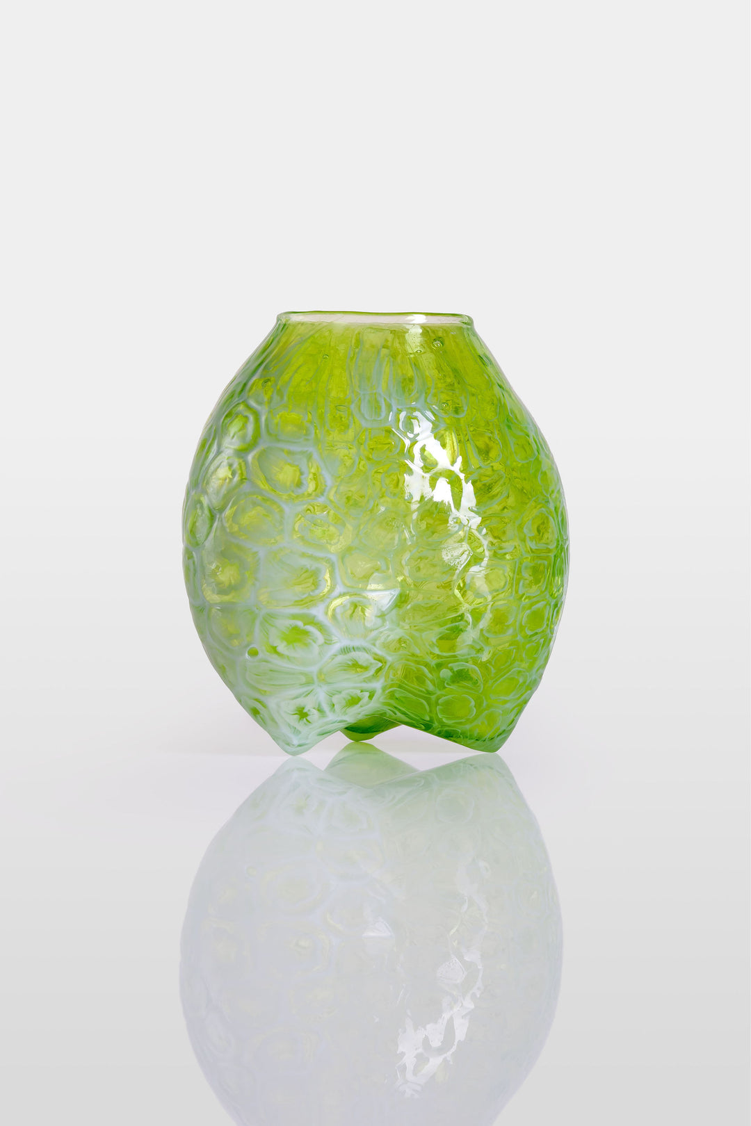 Blown green glass vessel with embossed floral-like texture and a softly bulbous form, featuring a subtly dimpled base and translucent finish.