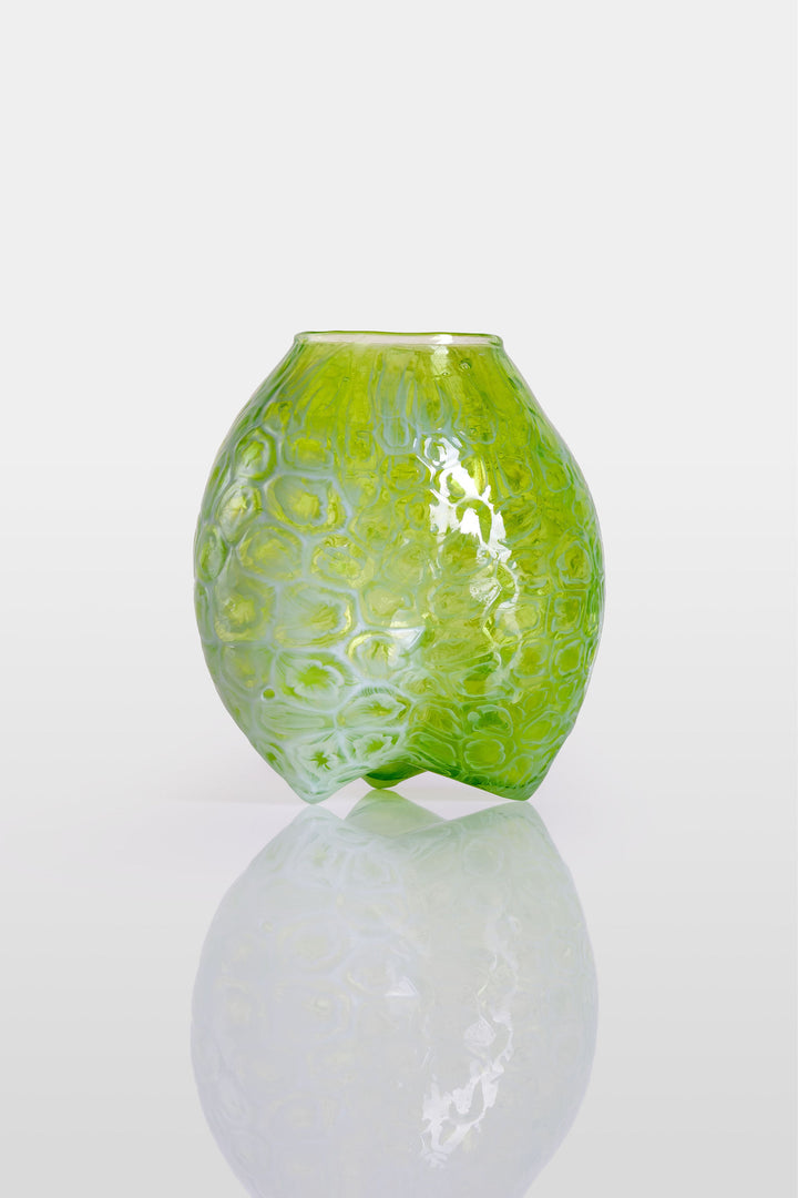 Blown green glass vessel with embossed floral-like texture and a softly bulbous form, featuring a subtly dimpled base and translucent finish.