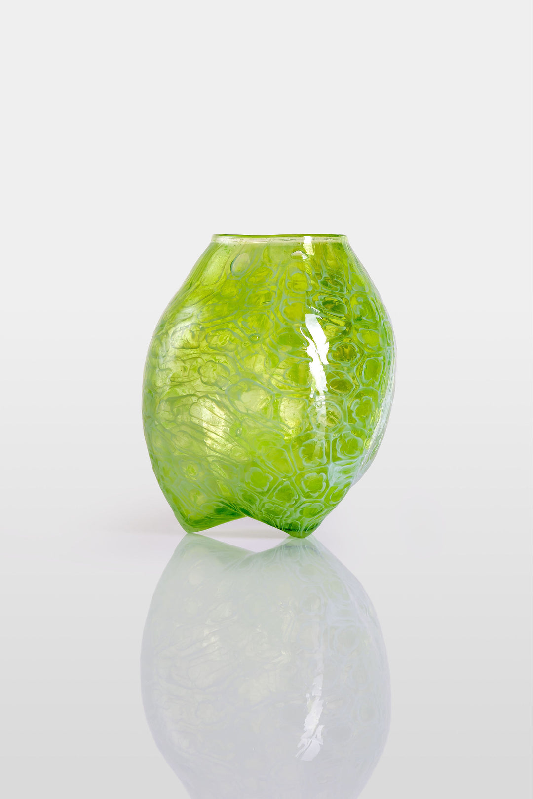 Blown green glass vessel with embossed floral-like texture and a softly bulbous form, featuring a subtly dimpled base and translucent finish.