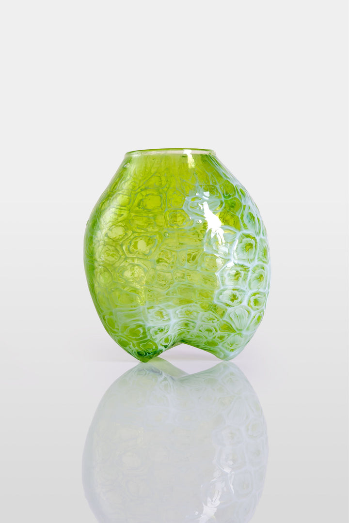 Blown green glass vessel with embossed floral-like texture and a softly bulbous form, featuring a subtly dimpled base and translucent finish.