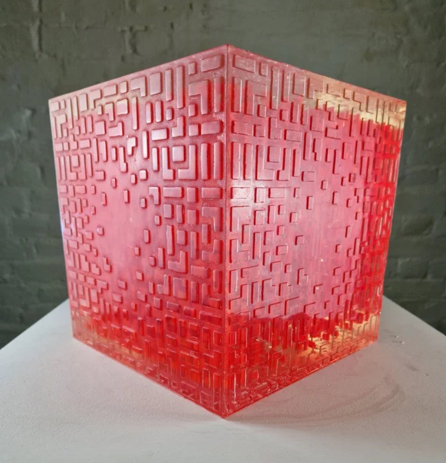 A one-off sculptural cube by Richard Slee, constructed from neon red acrylic and clear resin. The work features a dense, layered grid pattern that plays with light, depth, and shadow—creating a luminous, architectural object with a strong geometric presence. The cube glows from within, drawing the viewer into its intricate interior.