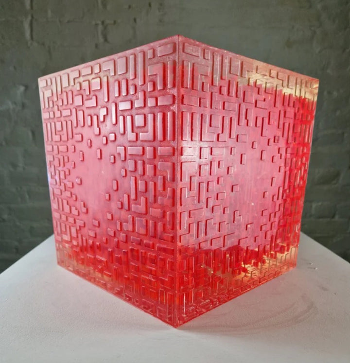 A one-off sculptural cube by Richard Slee, constructed from neon red acrylic and clear resin. The work features a dense, layered grid pattern that plays with light, depth, and shadow—creating a luminous, architectural object with a strong geometric presence. The cube glows from within, drawing the viewer into its intricate interior.
